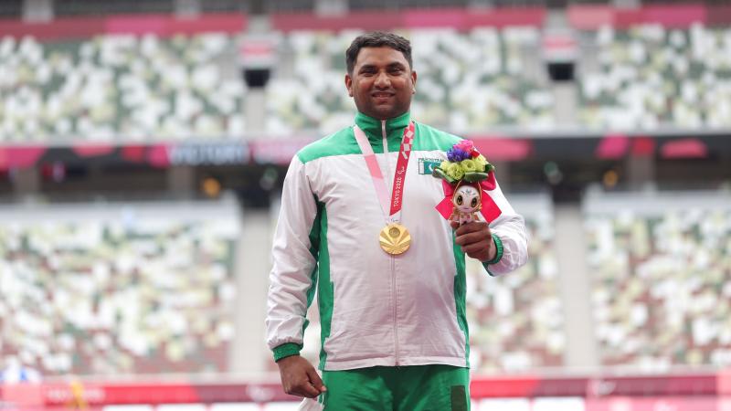 Pakistan's Haider Ali smiles on the podium with the gold medal