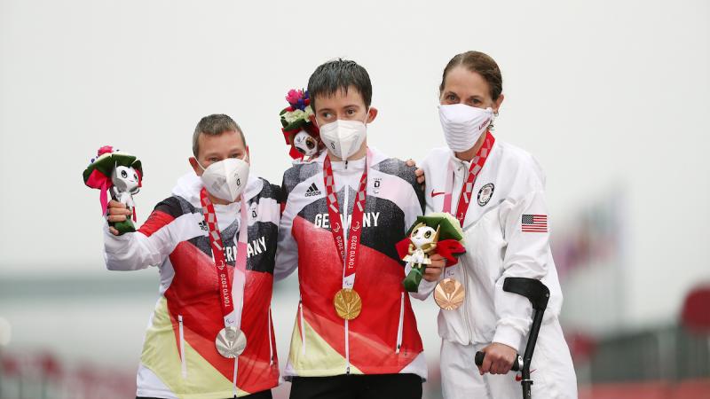 Three women on podium with medals