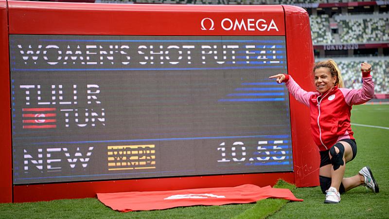 THE CHAMP: Raoua Tlili of Tunisia poses next to the digital scoreboard showing her World record in the women's shot put F41 at Tokyo 2020 Paralympic Games. 