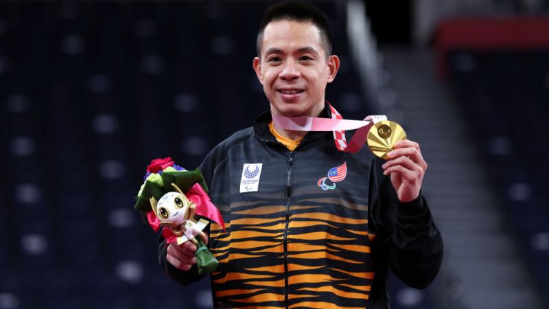 Malaysian man smiles with gold medal