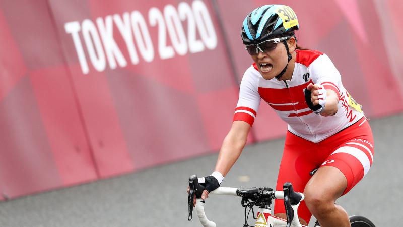 Japanese female cyclist celebrates on her bike