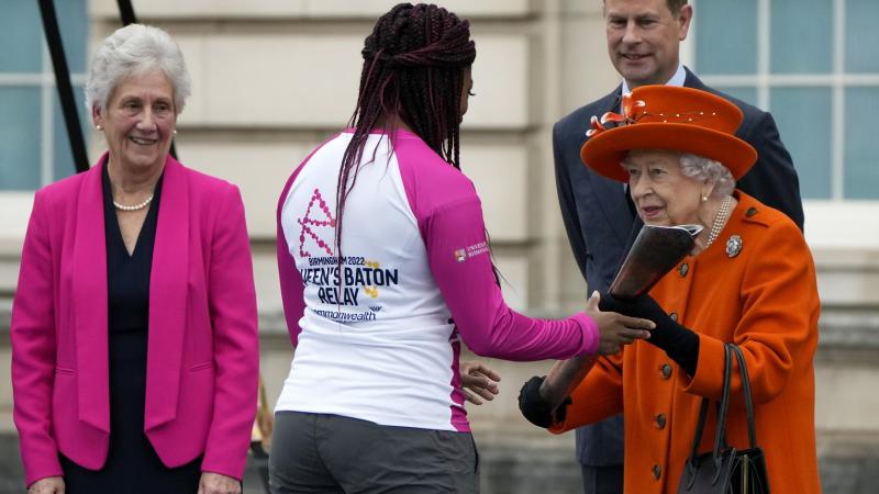 Queen Elizabeth II hands over the Queen's Baton to the first relay runner Kadeena Cox