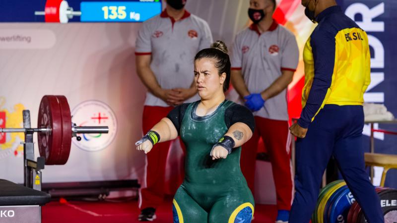 A woman preparing for her lift standing in front of the bar