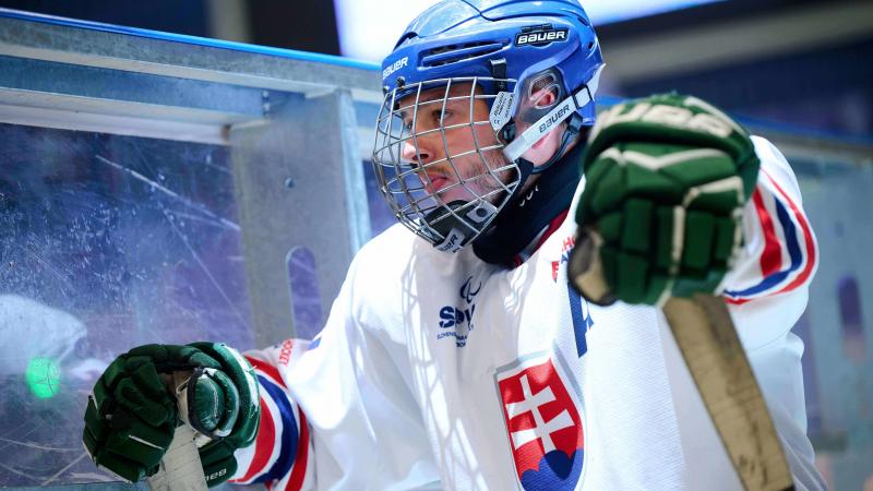 A Para ice hockey player gazing on the bench