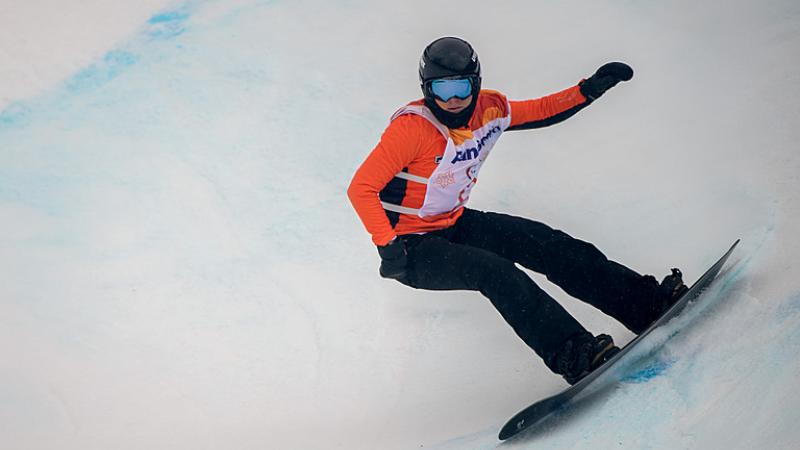 A female Para snowboarder riding with in a competition