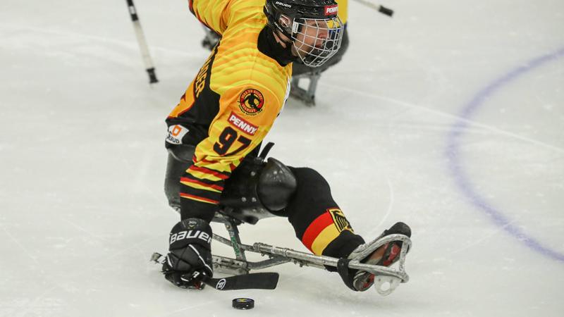 A Para ice hockey player with the Germany uniform on an ice rink