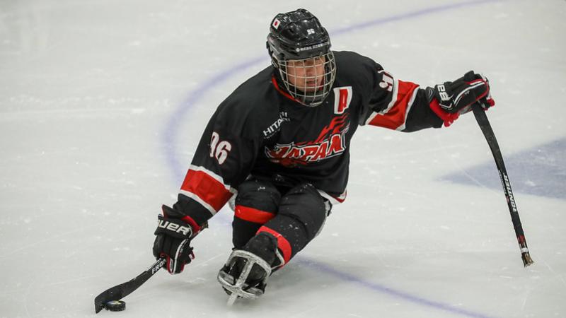 A male Para ice hockey player on ice with the Japanese uniform