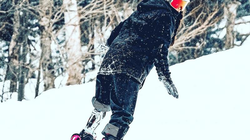A female Para snowboarder with a prosthetic leg riding in the snow