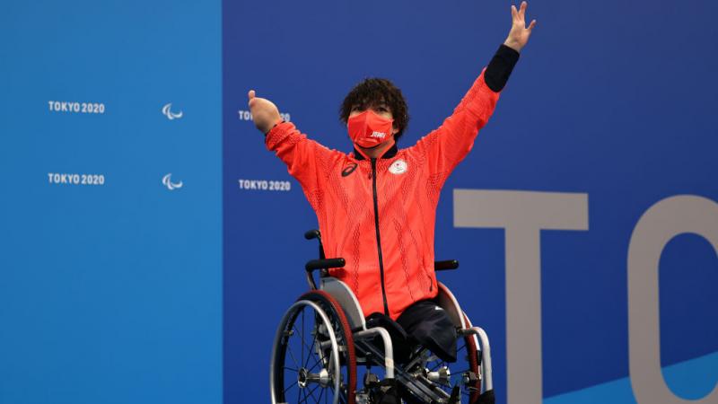 A man in a wheelchair with the uniform of Japan on a podium at the Tokyo 2020 Paralympic Games