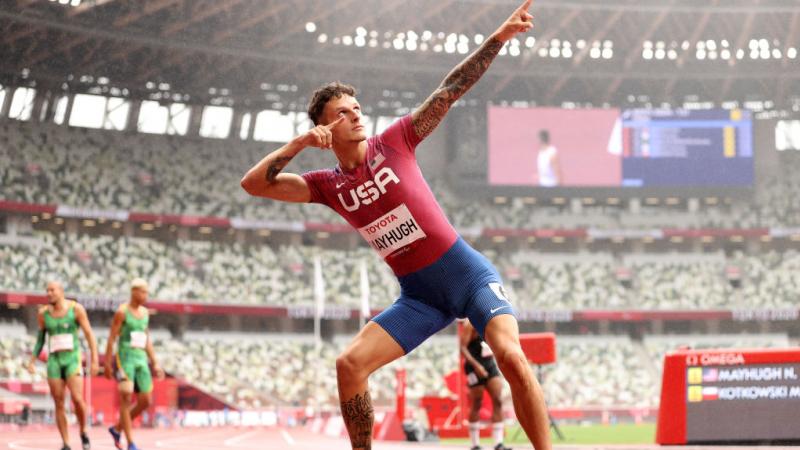 An athlete pointing towards the sky with his both hands in celebration.