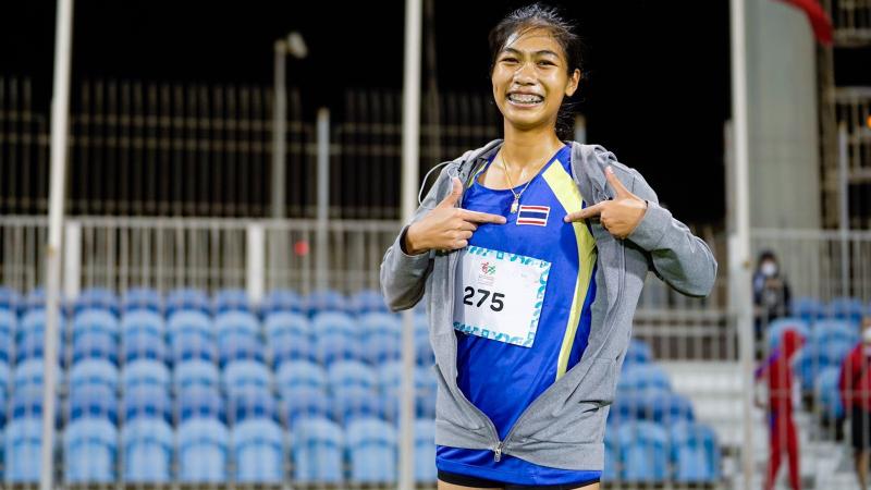 An athlete showing the flag of Thailand on her uniform