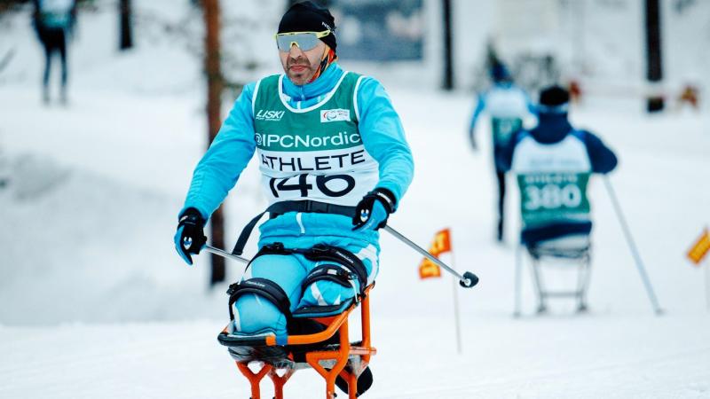 A male sit skier in a cross-country skiing competition