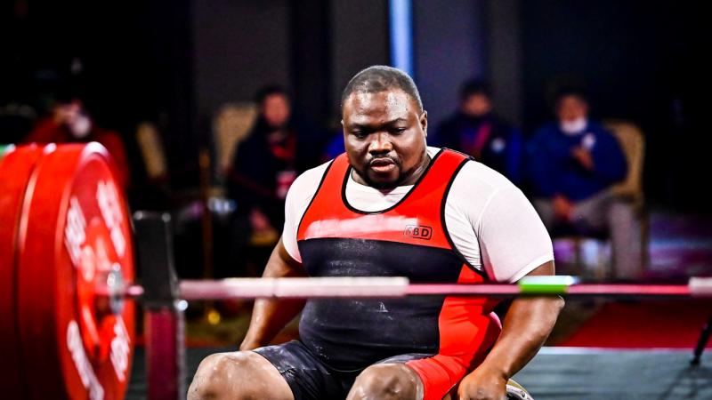 A man in a wheelchair in front of the bench concentrating before the lift