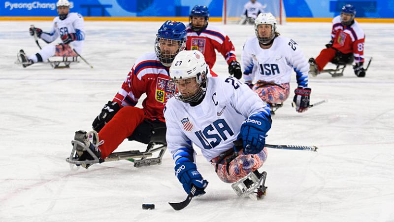 A male Para ice hockey player from Team USA in a game against Czech Republic