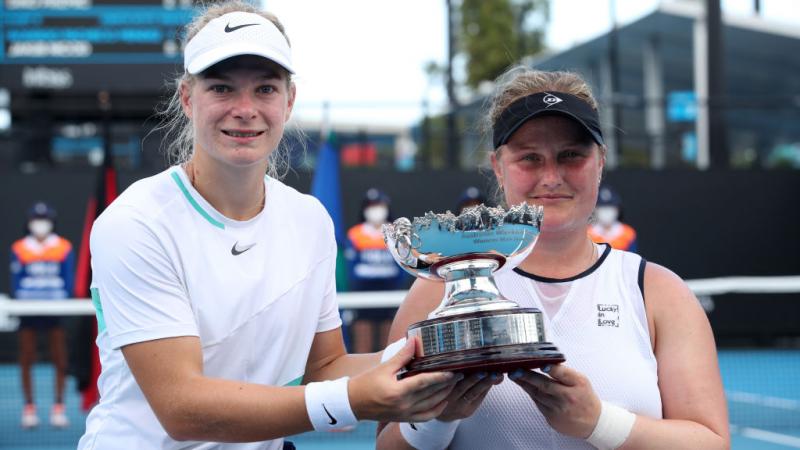 Diede De Groot and Aniek Van Koot of the Netherlands pose with the trophy after winning their women's Wheelchair doubles final match against Yui Kamiji of Japan and Lucy Shuker of Great Britain at the 2022 Australian Open.