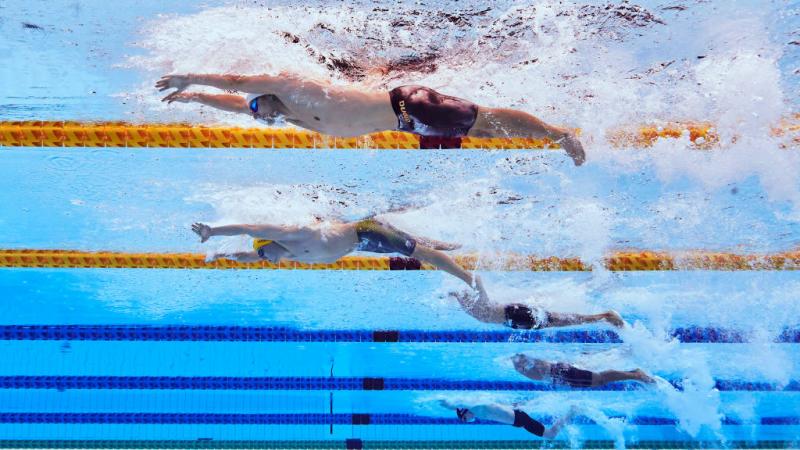 And underwater image of five men with disabilities in a swimming pool