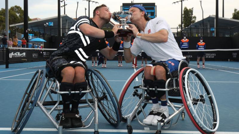 Alfie Hewett and Gordon Reid of Great Britain kiss the trophy after their victory in the men's Wheelchair Doubles final against Gustavo Fernandez of Argentina and Shingo Kunieda of Japan at the Australian Open.