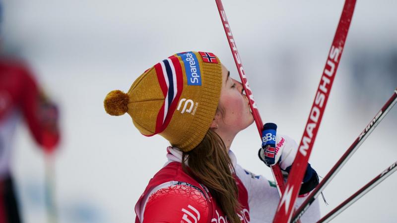 A female skier kissing her skis 