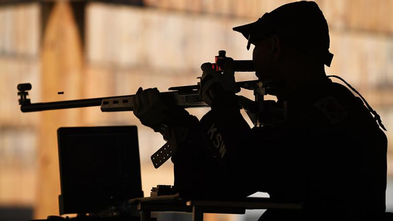 A male shooter with a rifle in a shooting range