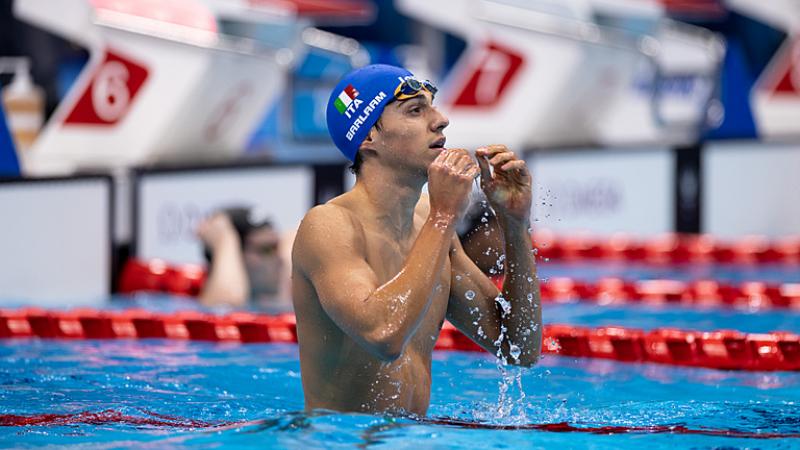 A male swimmer with a blue cap with the Italian flag in a swimming pool