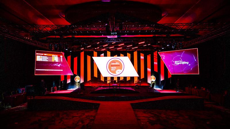 An empty stage with screens showing the logo of the Tbilisi 2021 World Para Powerlifting Championships