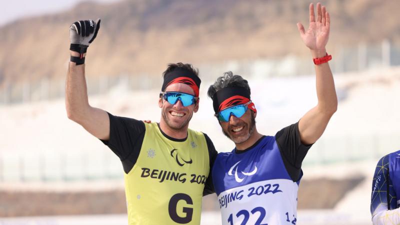 Gold medal winner Brian Mckeever (R) of Canada celebrates his win with guide Russ Kennedy in the Men's Sprint Free Technique Vision Impaired in the Beijing 2022 Paralympic Winter Games at Zhangjiakou National Biathlon Centre. 