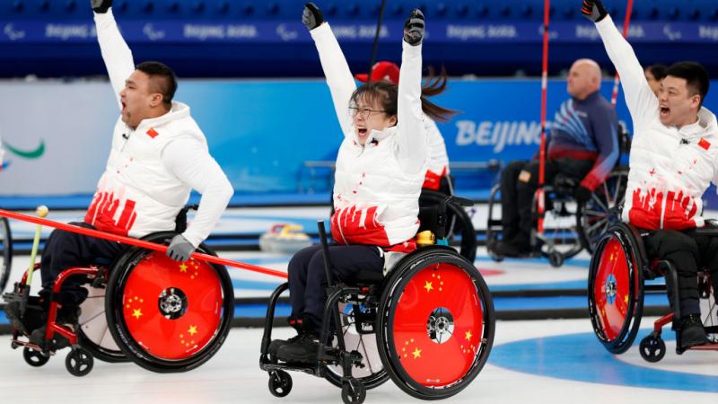 Chinese wheelchair curlers cheers with their arms in the airGett