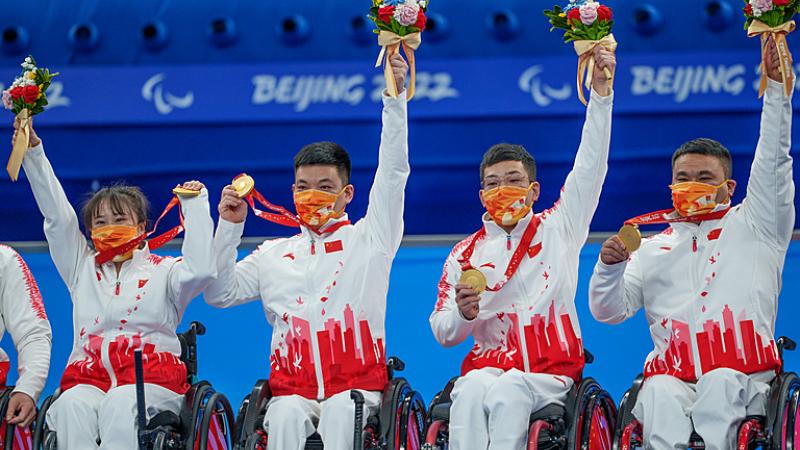 Chinese wheelchair curlers hold their gold medals in the air