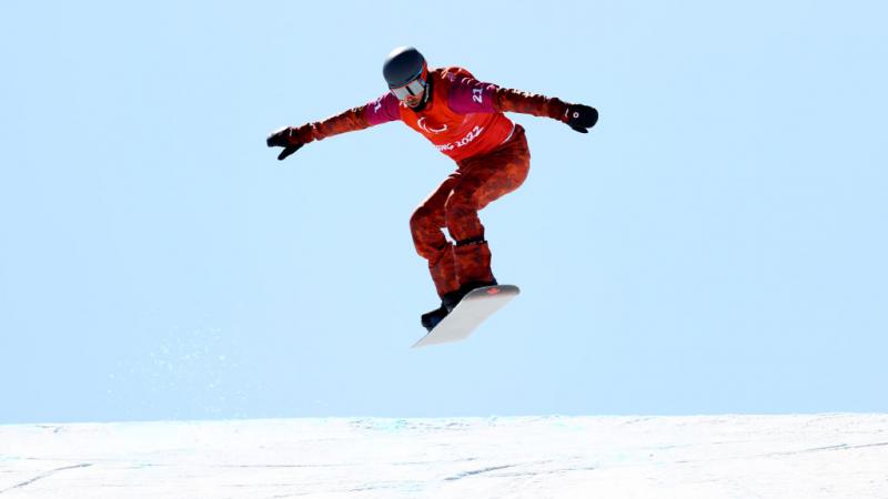 A male Para snowboarder in boardcross competition