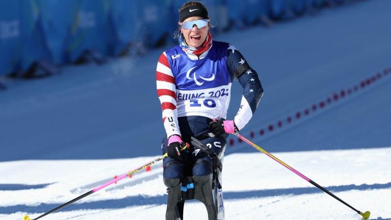 Oksana Masters reacts as she crosses the finish line in the women's Sprint Sitting Para Biathlon at the Beijing 2022 Winter Paralympics at Zhangjiakou National Biathlon Centre.