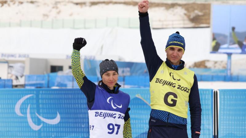Oksana Shyshkova of Ukraine and her guide Andriy Marchenko pose after winning the Para Biathlon Women's Individual Vision Impaired at the Beijing 2022 Paralympic Winter Games.