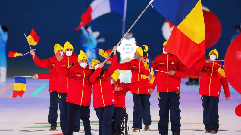 Laura Valeanu and Mihaita Papara carry the Romanian flag at the Opening Ceremony of Beijing 2022