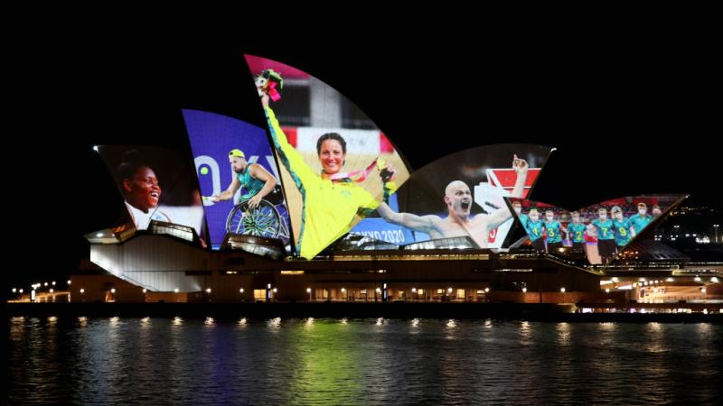 Photos of Australian Paralympians from Tokyo 2020 are projected on the Sydney Opera House at nighttime