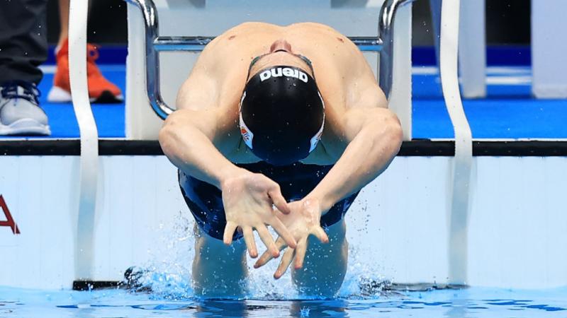 A male swimmer in the starting block in a backstroke race