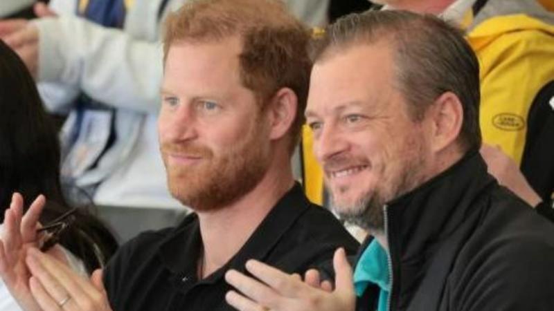 Prince Harry and IPC President Andrew Parsons sitting next to each other and clapping while watching the Invictus Games