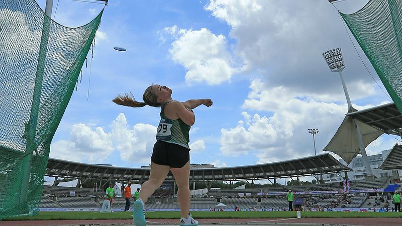 Image of a female Para Athletics in competition throwing a discus