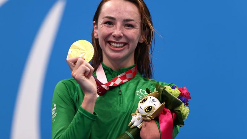 Image of a female Para swimmer in the podium after she grabbed gold