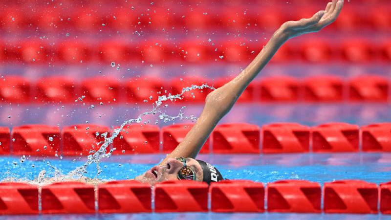 A male Para swimmer competing in a backstroke event