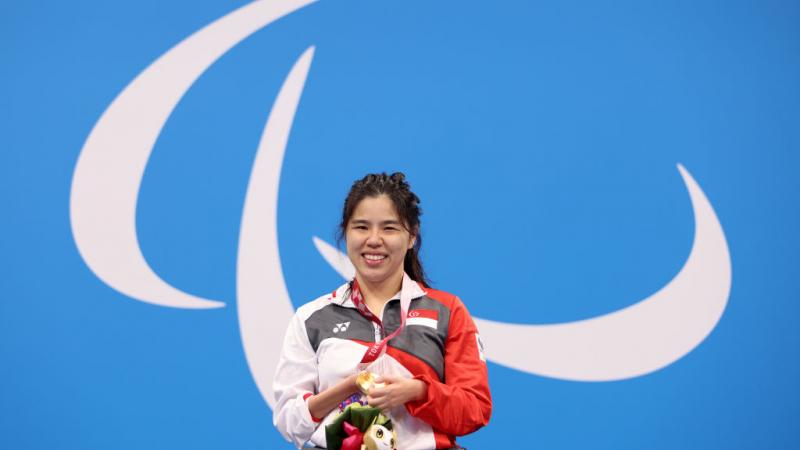Image of a female para swimmer in the podium after she grabbed gold