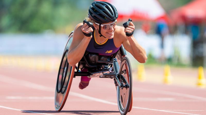 A female wheelchair racer celebrating on an athletics track