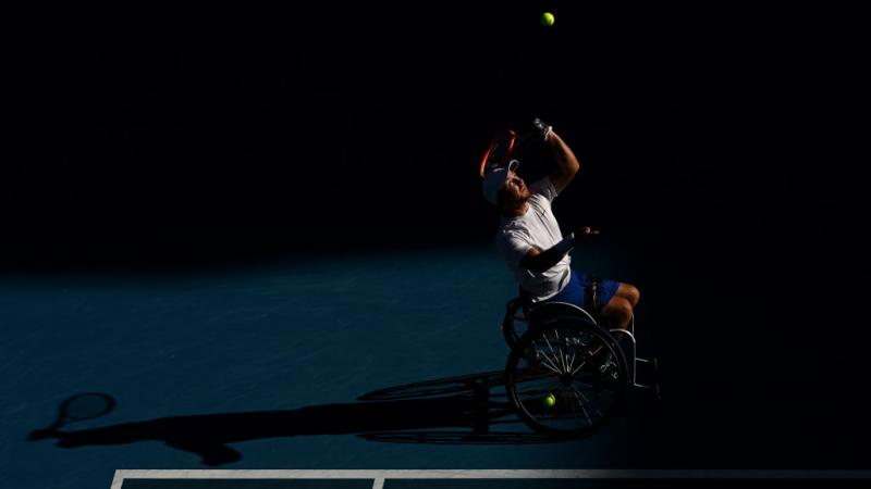 Dutch player Sam Schroder casts a shadow as he serves in the Australian Open final against Australia's Dylan Alcott.