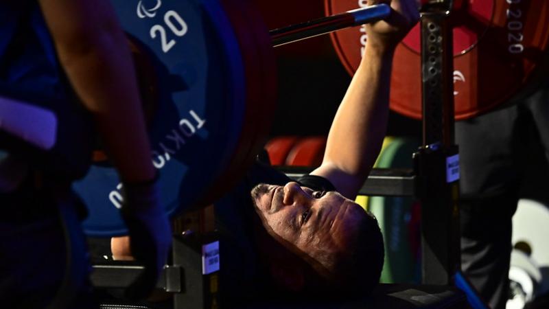 A man preparing to lift a bar on a bench press