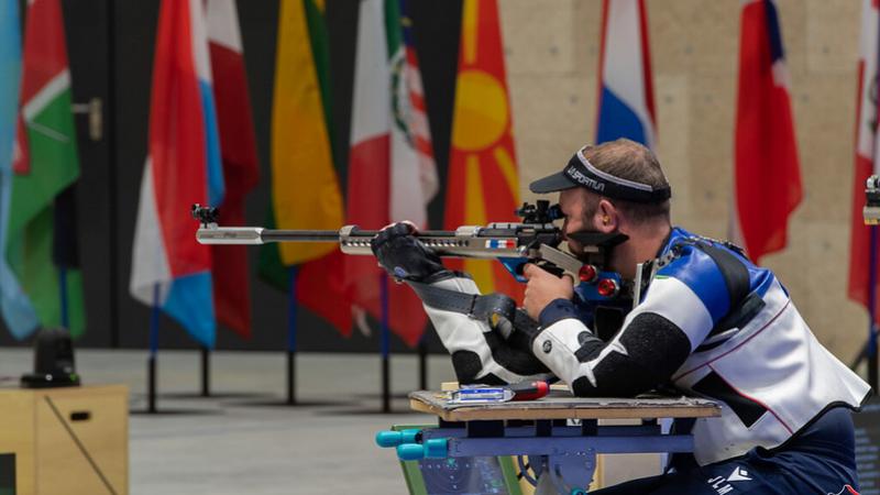 A male athlete shooting with a rifle in a shooting Para sport competition
