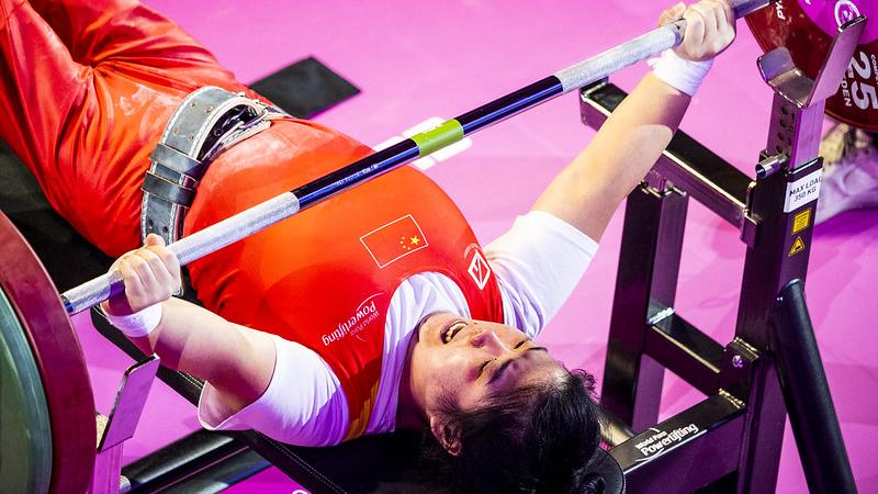 A female Para powerlifter lifting the bar