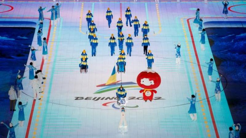 Flagbearer Maksym Yarovyi, a Ukrainian flag attached to his wheelchair, leads the Ukrainian delegation into the Opening Ceremony of the Beijing 2022 Winter Paralympic Games.