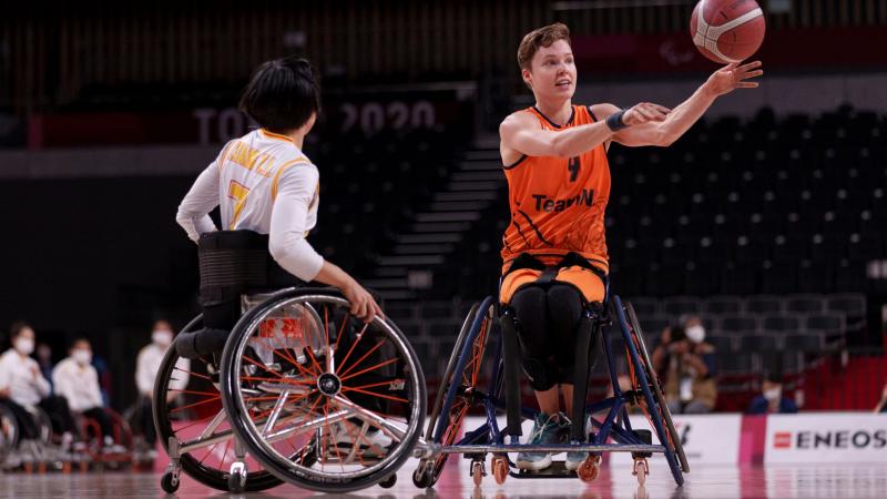 Bo Kramer makes a pass during the gold medal match at Tokyo 2020 as a Chinese player faces her.