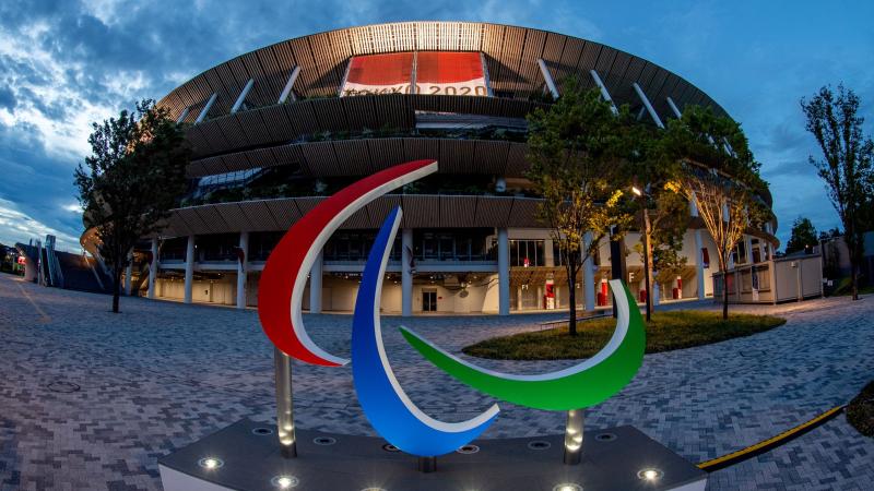 The Agitos sign in front of the Tokyo Stadium at dusk.