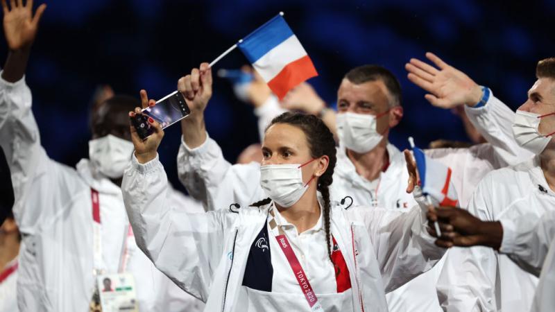 French athletes wave small flags during the athletes' parade at the Tokyo 2020 Opening Ceremony.