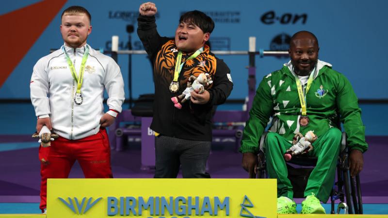 Malaysia's Bonnie Bunyau Gustin celebrates his gold medal on the podium.