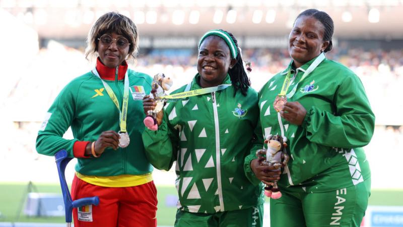  Eucharia Iyazi (centre) of Nigeria with her team mate and bronze medallist Ugochi Alam and silver medallist Arlette Mawe Fokoa of Cameroon pose for a photo during the medal ceremony for the women's shot put F55-57 at the Birmingham 2022 Commonwealth Games.